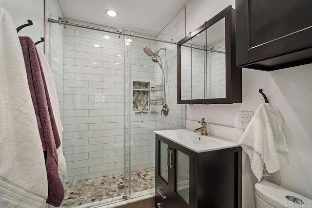 bathroom featuring toilet, vanity, and walk in shower