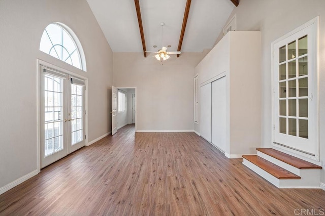 interior space featuring french doors, ceiling fan, high vaulted ceiling, beamed ceiling, and light hardwood / wood-style floors