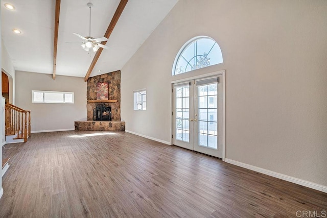 unfurnished living room with french doors, ceiling fan, dark wood-type flooring, high vaulted ceiling, and beamed ceiling