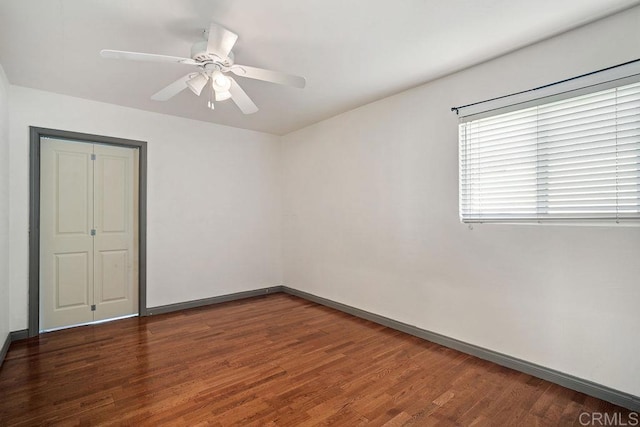 spare room with ceiling fan and dark hardwood / wood-style flooring