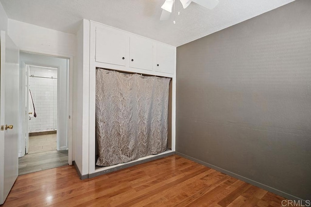 unfurnished bedroom featuring light hardwood / wood-style floors, a closet, and ceiling fan