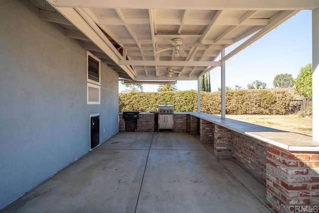 view of patio / terrace featuring ceiling fan, area for grilling, and exterior kitchen