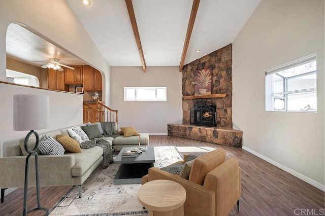 living room with ceiling fan, plenty of natural light, lofted ceiling with beams, and hardwood / wood-style flooring