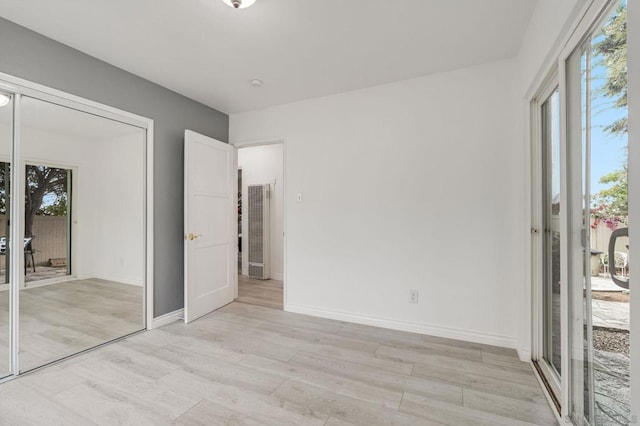 unfurnished bedroom with a closet and light hardwood / wood-style flooring