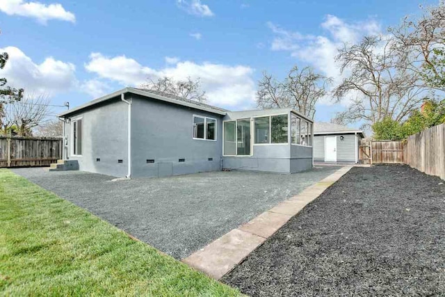 rear view of house with a shed and a yard