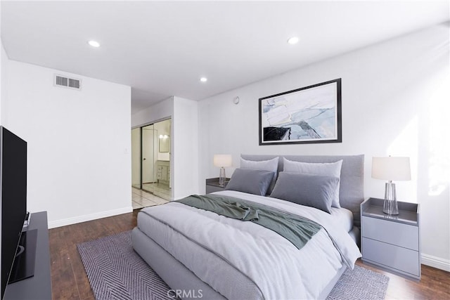 bedroom featuring hardwood / wood-style flooring and ensuite bath