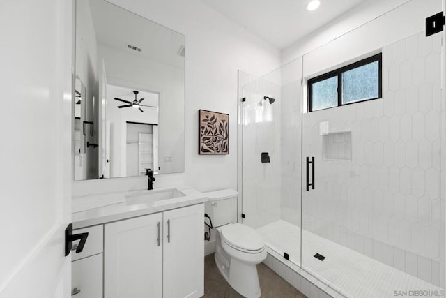 bathroom with ceiling fan, vanity, a shower with door, and toilet