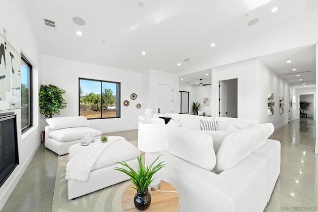 living room featuring ceiling fan and concrete flooring