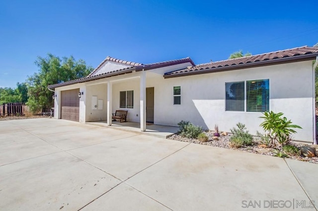 back of property with a porch and a garage