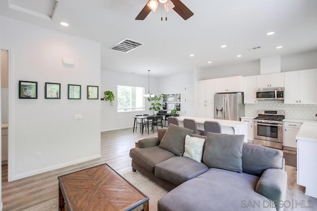 living room featuring light wood-type flooring and ceiling fan