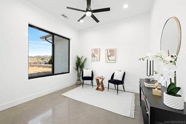 living area featuring ceiling fan and concrete floors