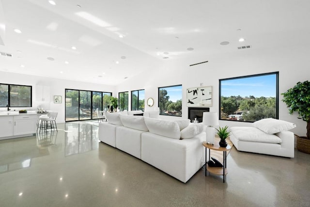 living room with a fireplace and high vaulted ceiling