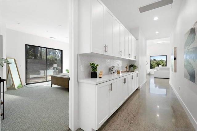 interior space with backsplash and white cabinetry