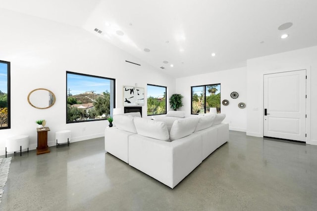 living room featuring concrete flooring and vaulted ceiling