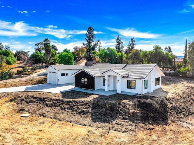 view of front of home featuring a garage and a patio