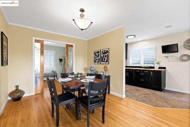 dining room featuring light hardwood / wood-style floors and crown molding