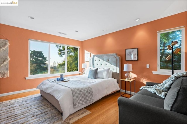 bedroom featuring ornamental molding and light hardwood / wood-style floors