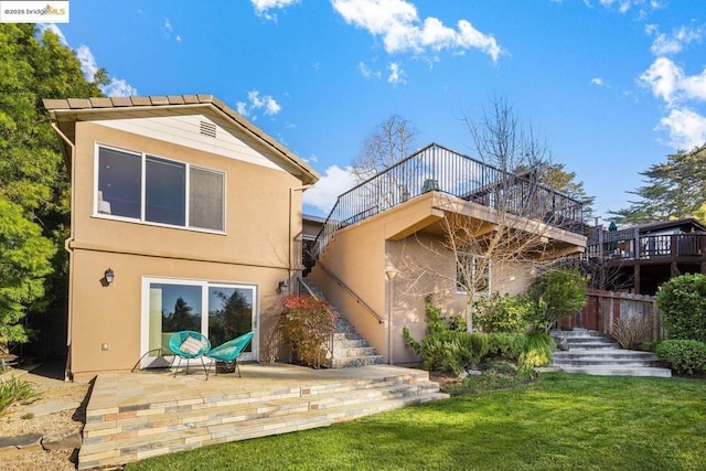 rear view of house with a patio area and a lawn