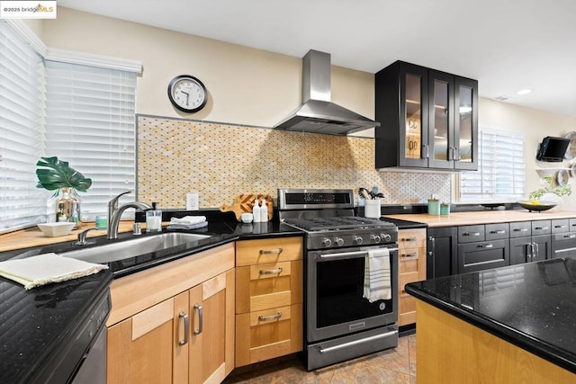 kitchen with black dishwasher, backsplash, stainless steel gas stove, range hood, and sink