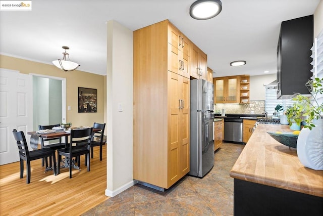 kitchen featuring decorative light fixtures, backsplash, and appliances with stainless steel finishes