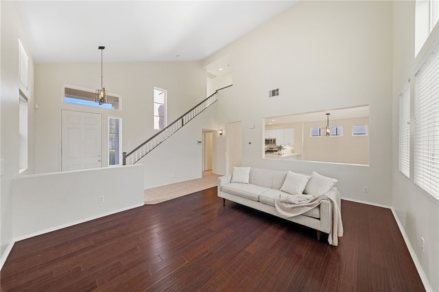 living room with dark hardwood / wood-style flooring and high vaulted ceiling