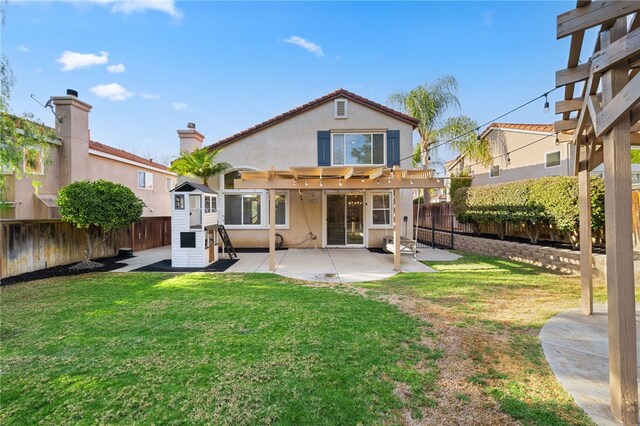 rear view of house with a pergola, a yard, and a patio area