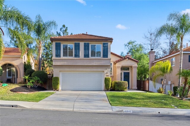 mediterranean / spanish home featuring a front yard and a garage