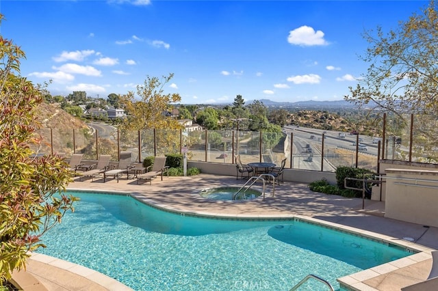 view of pool with a hot tub and a patio