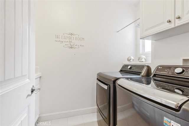 clothes washing area featuring cabinets and washing machine and dryer