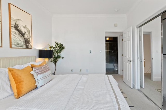 bedroom with a barn door, a closet, ornamental molding, and carpet flooring