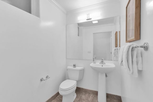 bathroom with toilet, sink, and ornamental molding