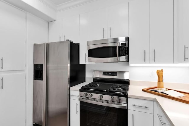 kitchen featuring white cabinetry, crown molding, and stainless steel appliances