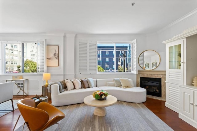 living room with dark hardwood / wood-style flooring, crown molding, and a fireplace