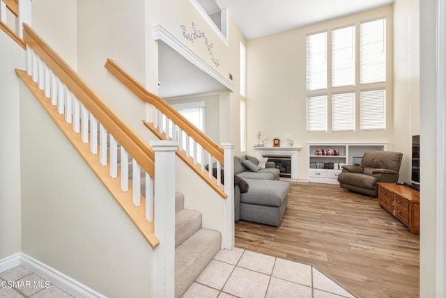 living room with a towering ceiling and light tile patterned flooring