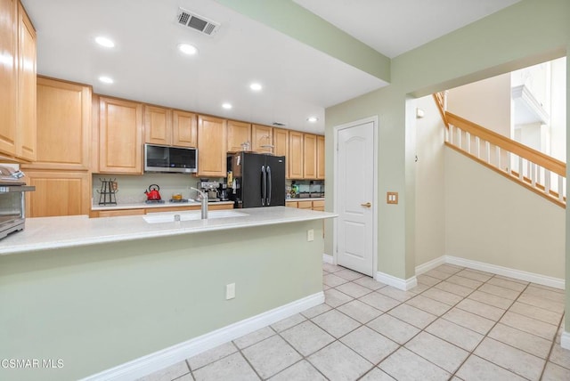 kitchen featuring kitchen peninsula, sink, light brown cabinets, stainless steel appliances, and light tile patterned floors