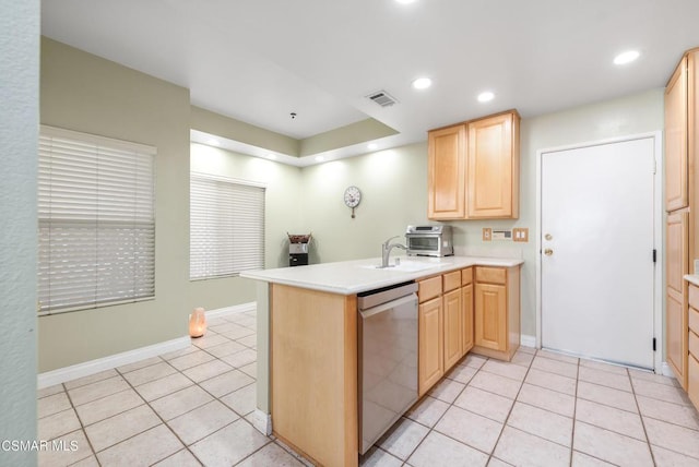 kitchen featuring stainless steel dishwasher, light tile patterned floors, kitchen peninsula, and light brown cabinetry