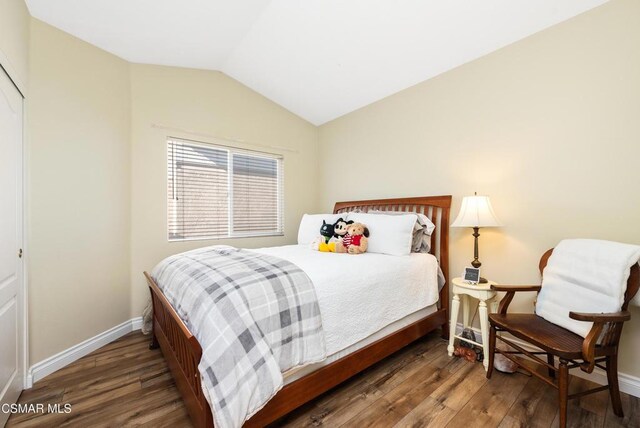 bedroom featuring dark hardwood / wood-style flooring and lofted ceiling