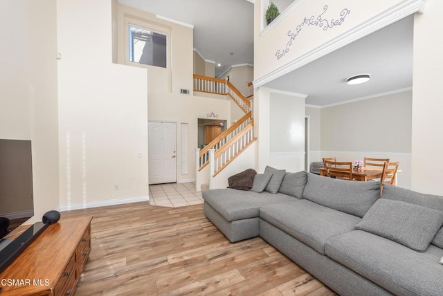 living room featuring a high ceiling, crown molding, and light hardwood / wood-style flooring