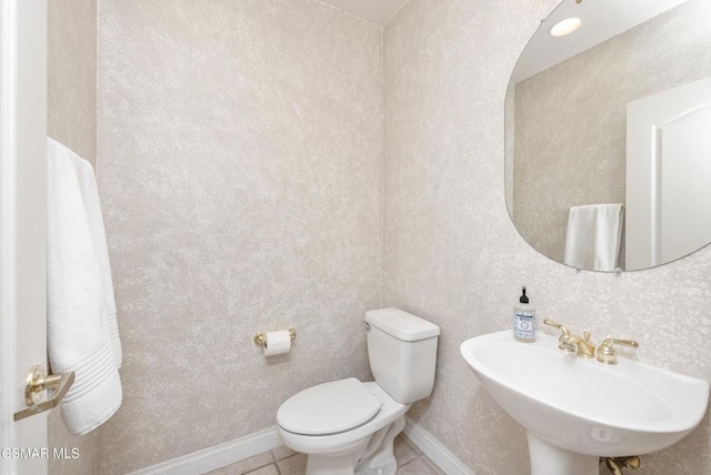 bathroom featuring sink, toilet, and tile patterned flooring