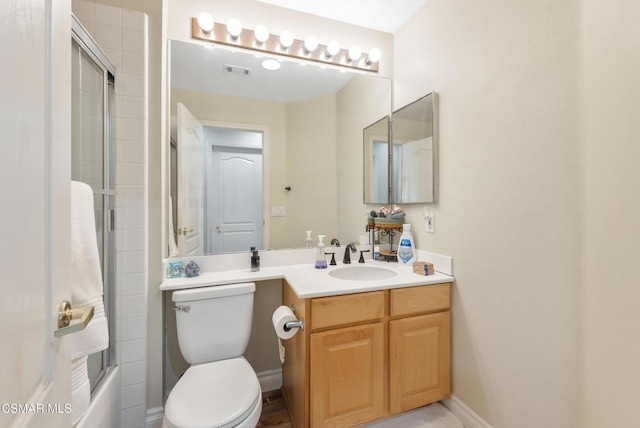 full bathroom with bath / shower combo with glass door, toilet, and vanity