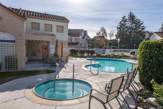 view of pool with a hot tub and a patio area