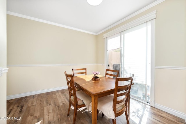 dining area with hardwood / wood-style flooring and ornamental molding