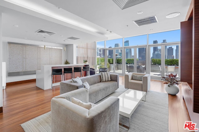 living room with light hardwood / wood-style flooring, french doors, and expansive windows