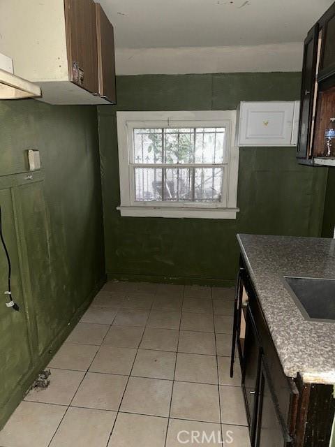 kitchen featuring dark brown cabinets and light tile patterned flooring