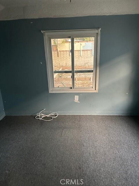 carpeted empty room featuring a textured ceiling