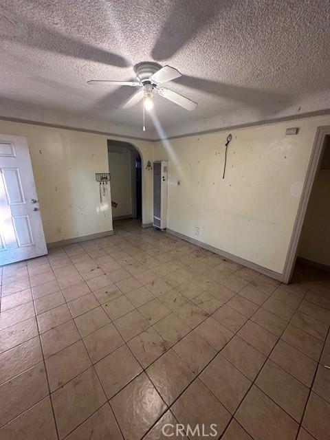 spare room with ceiling fan and a textured ceiling