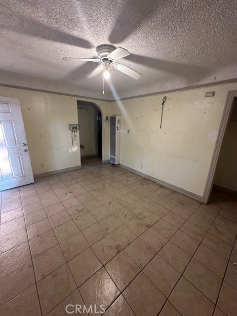 unfurnished room featuring ceiling fan and a textured ceiling