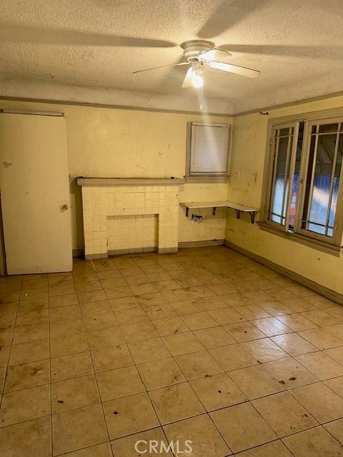 unfurnished room with a textured ceiling and ceiling fan