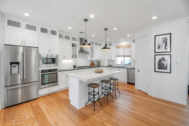 kitchen featuring appliances with stainless steel finishes, sink, white cabinetry, and a center island