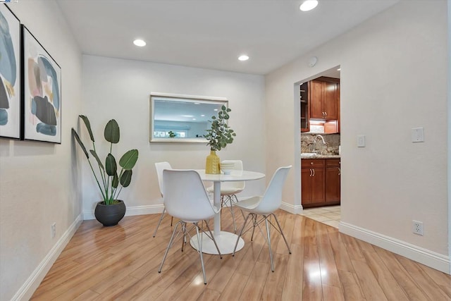 dining space featuring sink and light hardwood / wood-style flooring